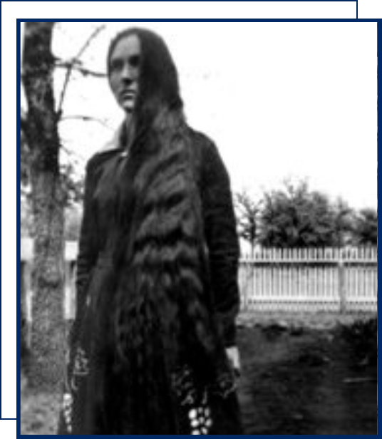 A woman standing in front of a tree.