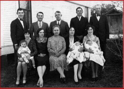 A group of people that are sitting in front of a building.