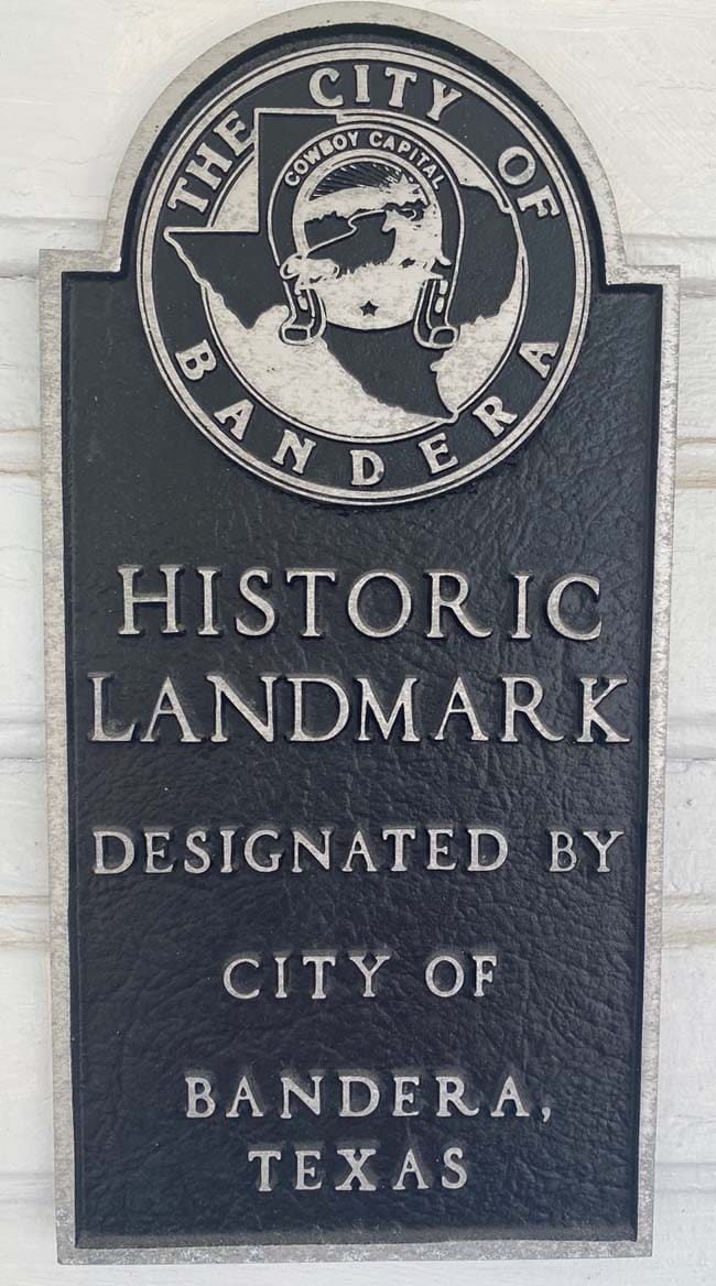 A sign that says historic landmark designated by city of bandera.