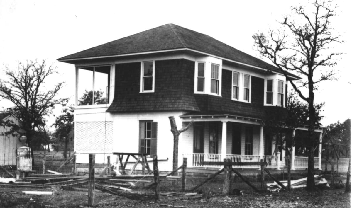 A black and white photo of an old house.